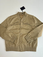 Tan bomber jacket front with embroidered chest design and snap buttons