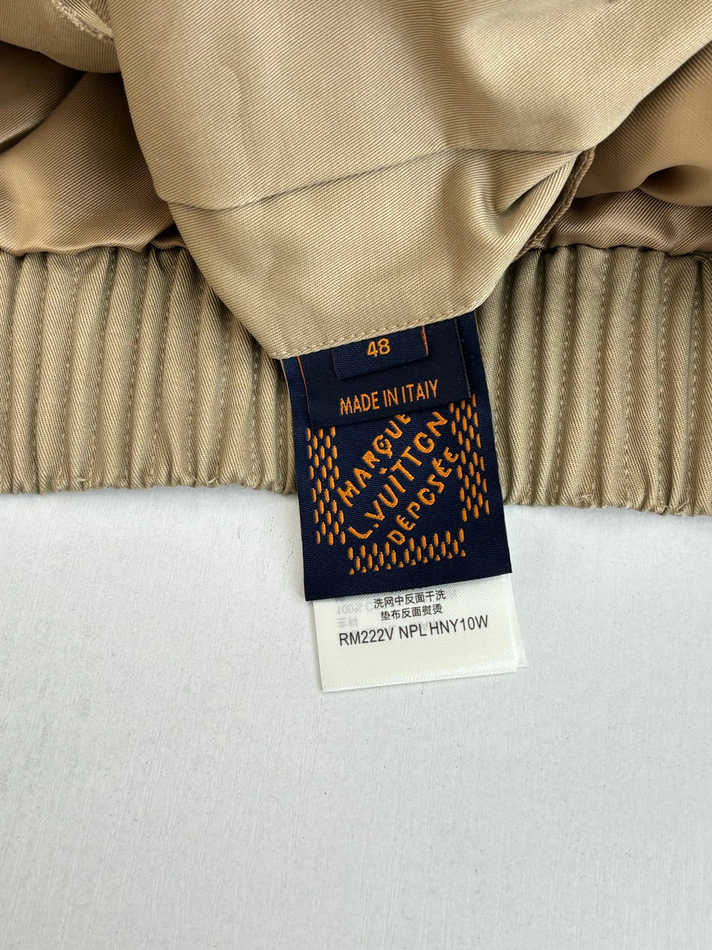 Beige jacket with inner label showing Made in Italy and Louis Vuitton branding