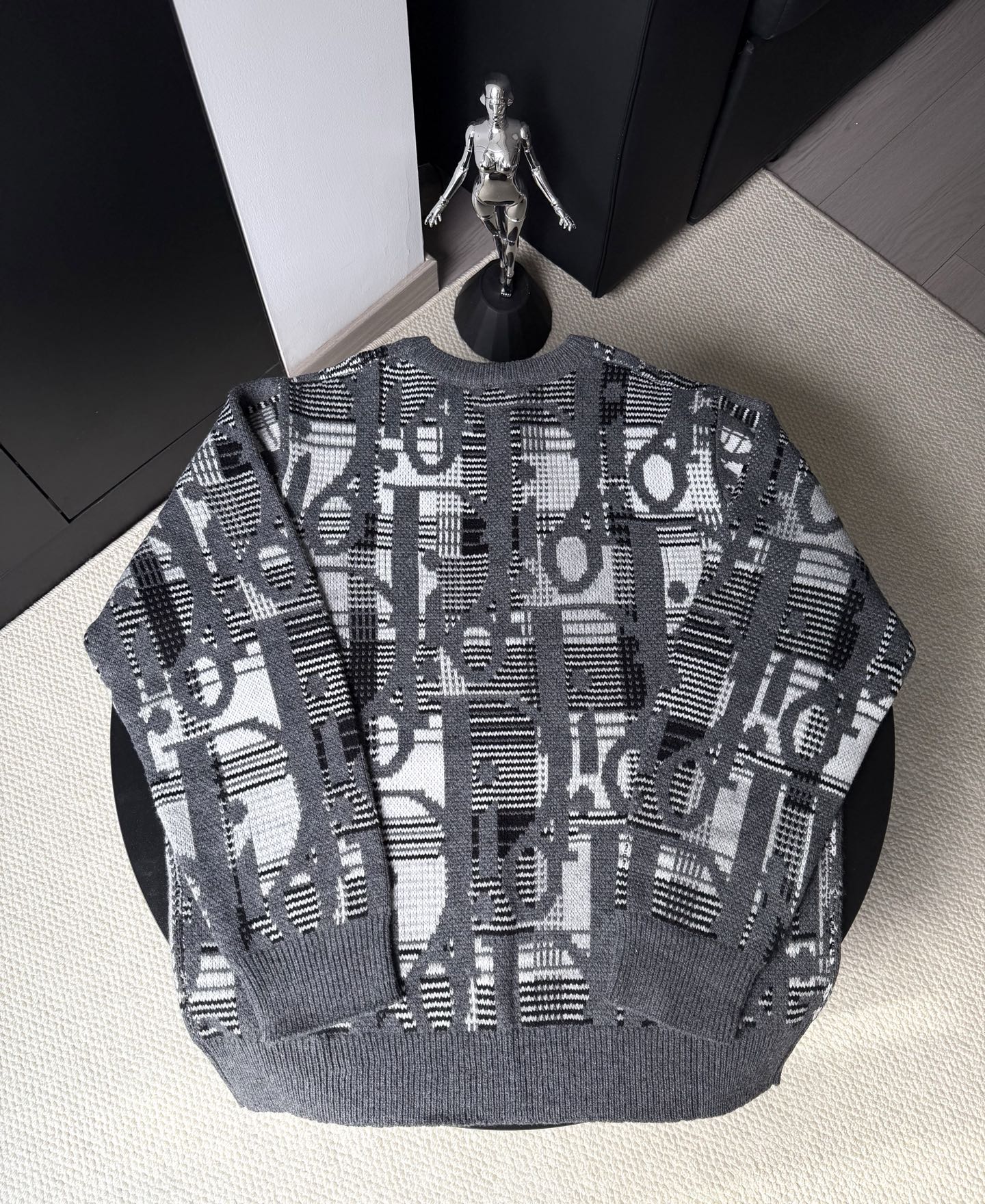 Gray knit sweater with long sleeves and abstract black-and-white logo pattern