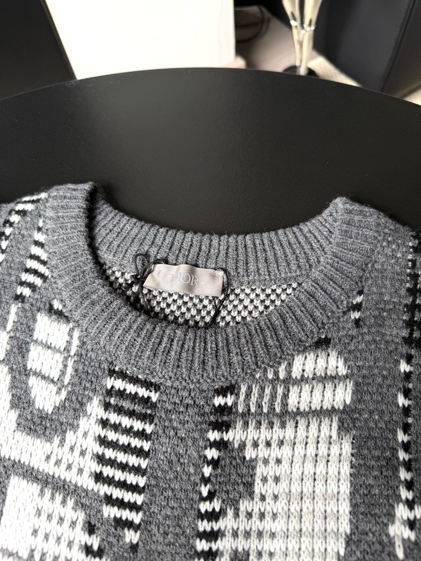 Gray sweater neckline with ribbed collar and black-and-white graphic knit pattern