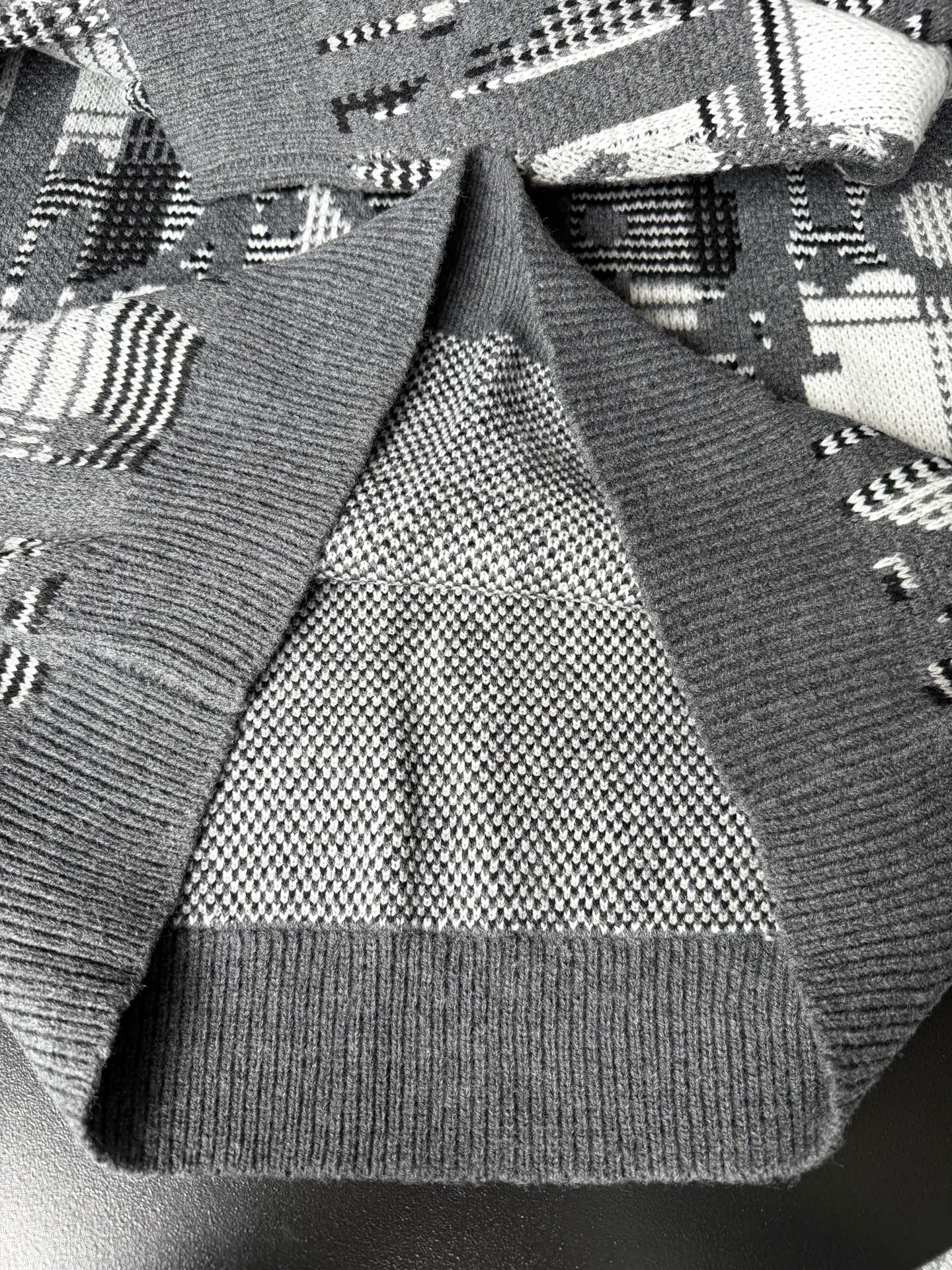 Gray sweater cuffs and hem with black-and-white knit pattern and ribbed trim