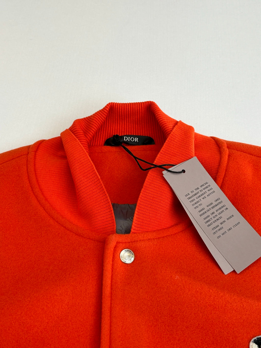 Orange ribbed collar varsity jacket with button placket, inner tags under collar
