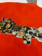 Orange jacket front with dense ornate embroidered applique across the chest