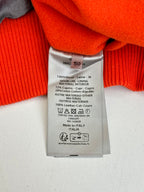 Orange jacket neck label and care tag showing 100% wool and leather