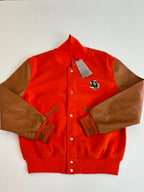 Orange varsity jacket with brown leather-look sleeves, snap front, embroidered crest