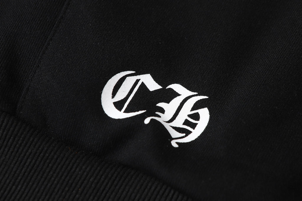 Black hoodie sleeve close-up of white embroidered logo patch.