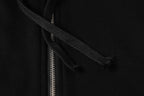 Black hoodie close-up of neckline and zipper track with hood seam.