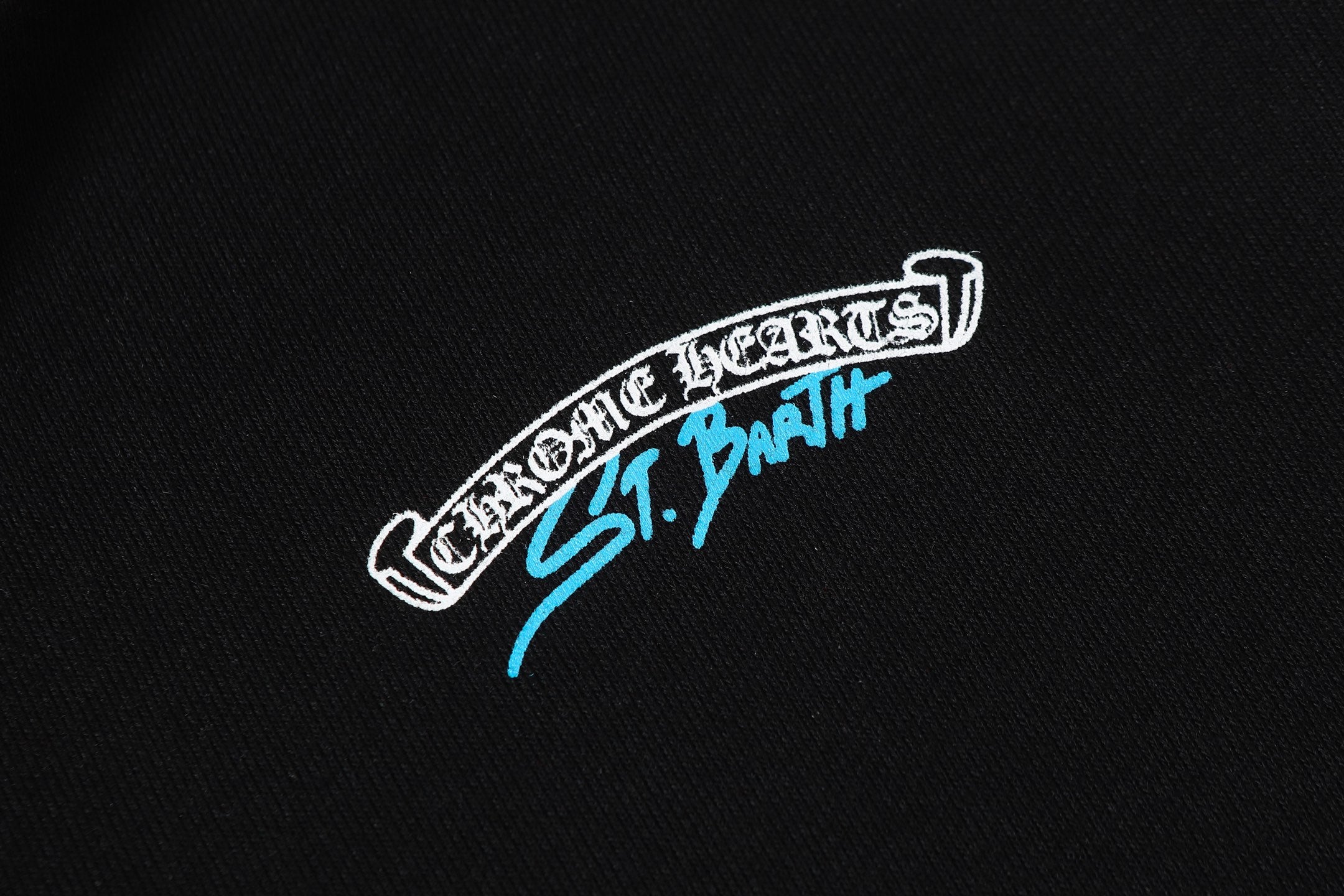 Black hoodie chest logo patch in white and blue, stitched look.
