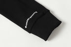 Black long-sleeve top cuff with small embroidered logo