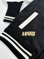 Louis Vuitton varsity jacket sleeve cuff close-up with ribbed stripes and gold “LOUIS” lettering