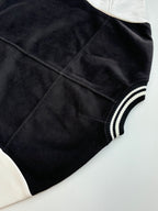 Louis Vuitton varsity jacket side view with smooth black fabric and ribbed striped collar cuff