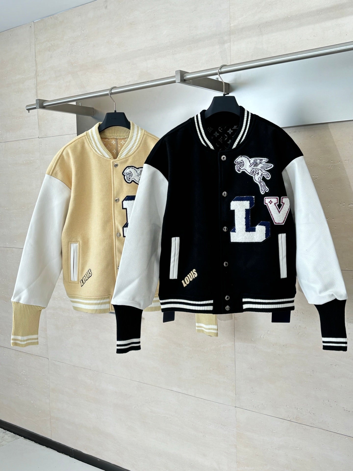 Louis Vuitton varsity jacket set on hangers: black and white style, plus beige contrasting jacket