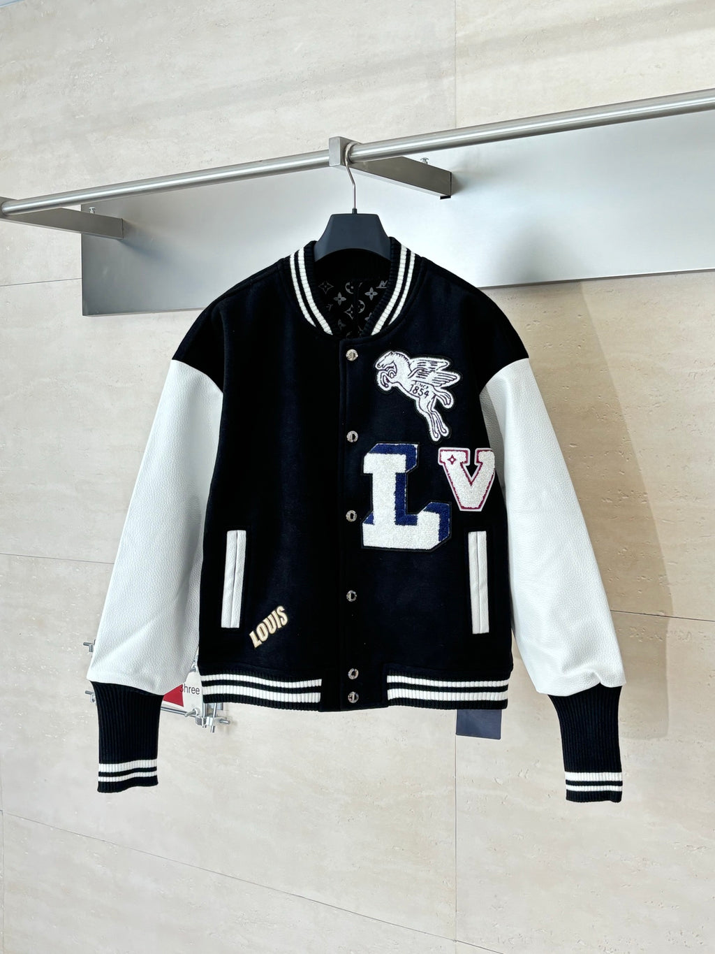 Louis Vuitton varsity jacket with black body, white sleeves, snap buttons, striped cuffs