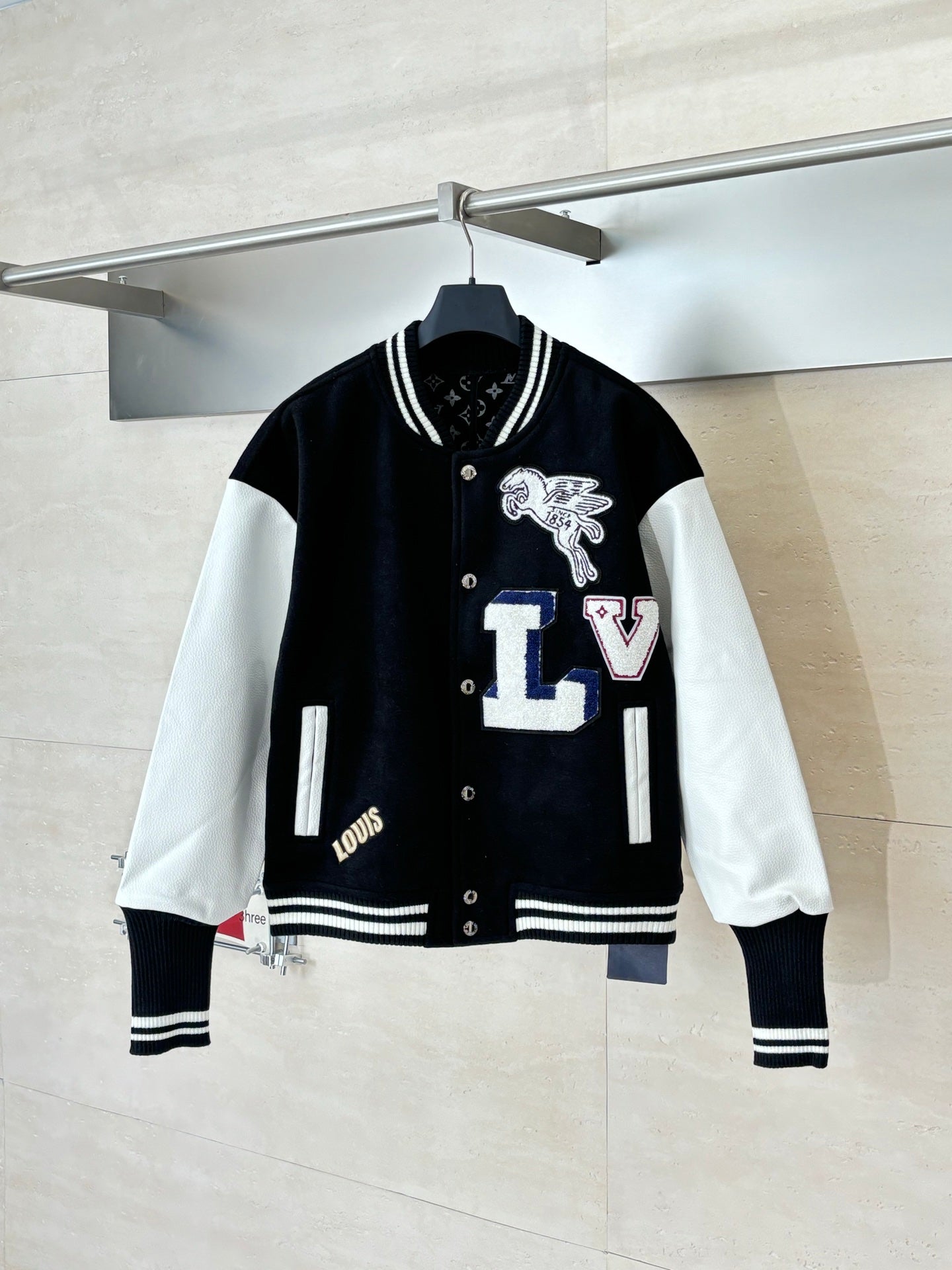 Louis Vuitton varsity jacket with black body, white sleeves, snap buttons, striped cuffs