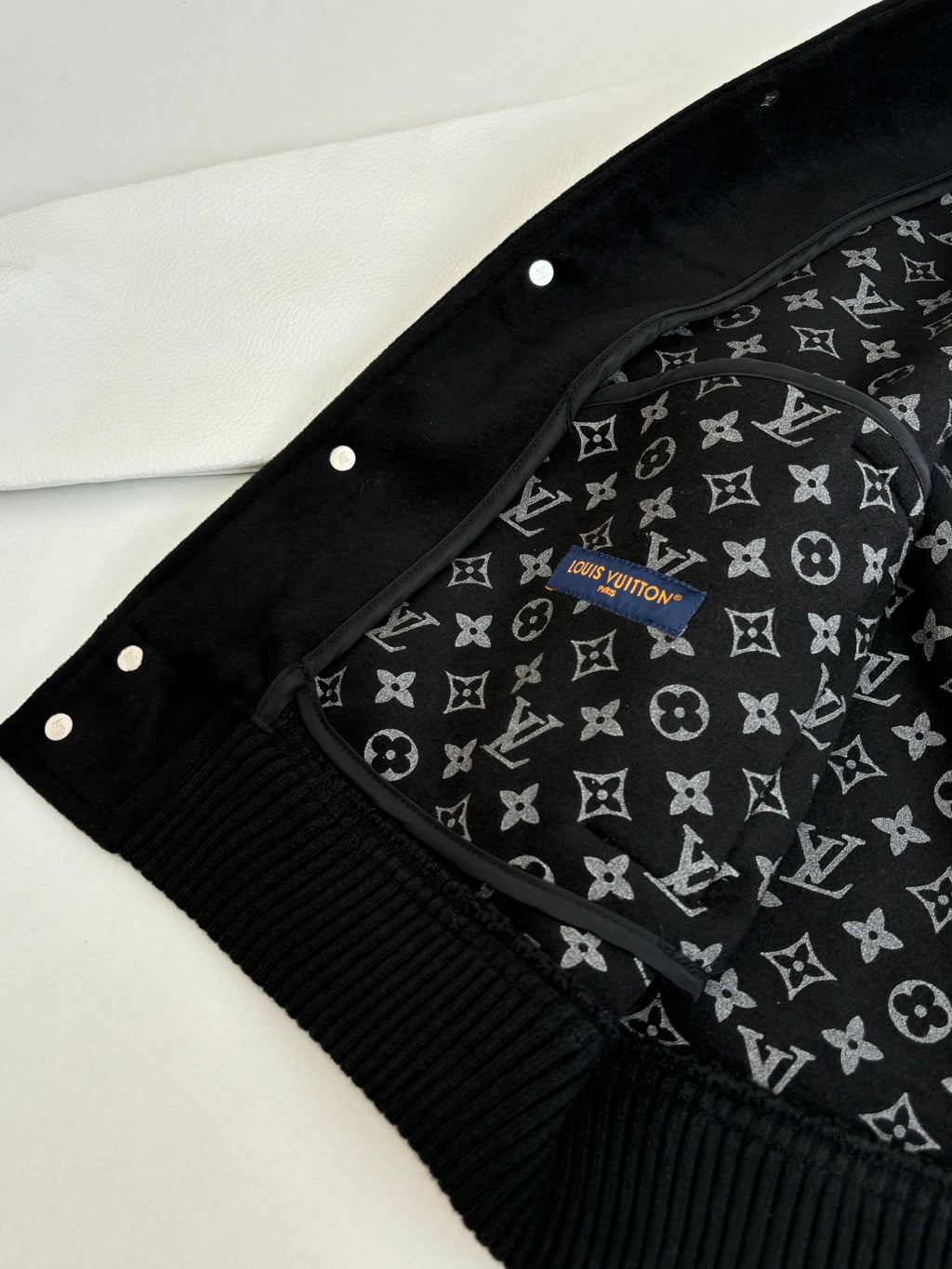 Louis Vuitton varsity jacket hood area with black fabric lining and repeating monogram print