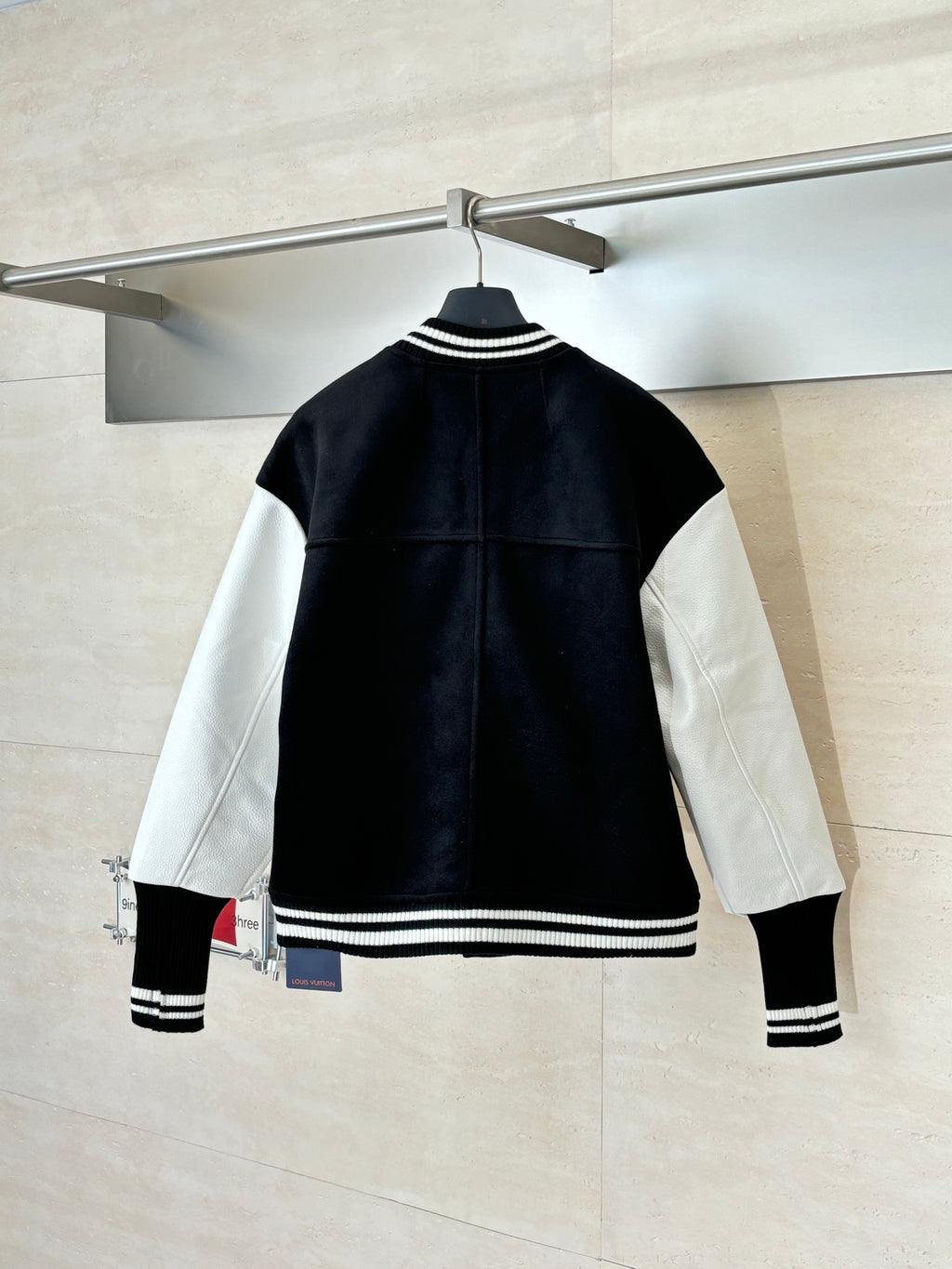 Louis Vuitton varsity jacket back view with black body and white contrast sleeves, ribbed hem