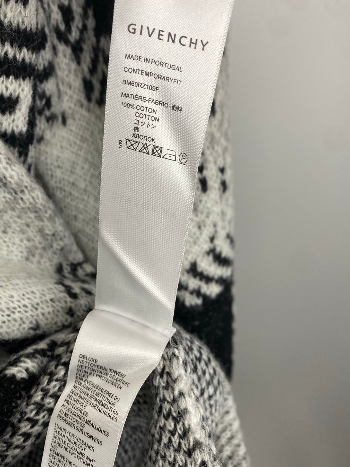 Givenchy clothing care label on white-and-black patterned knit sweater