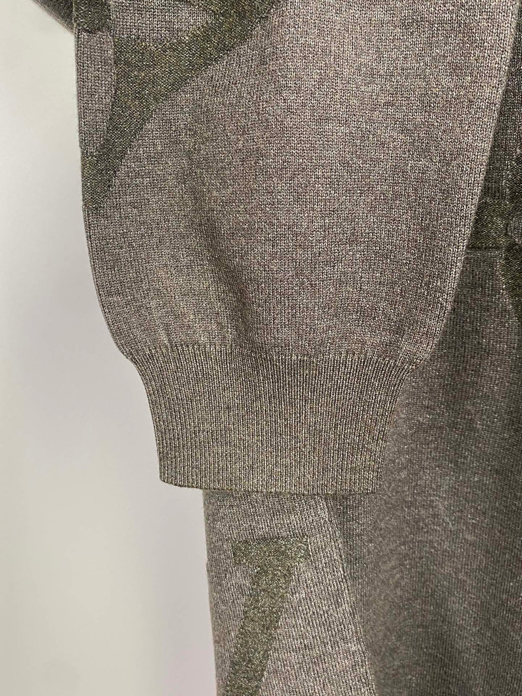 Grey knit sweater sleeve and ribbed hem cuff, logo pattern detail