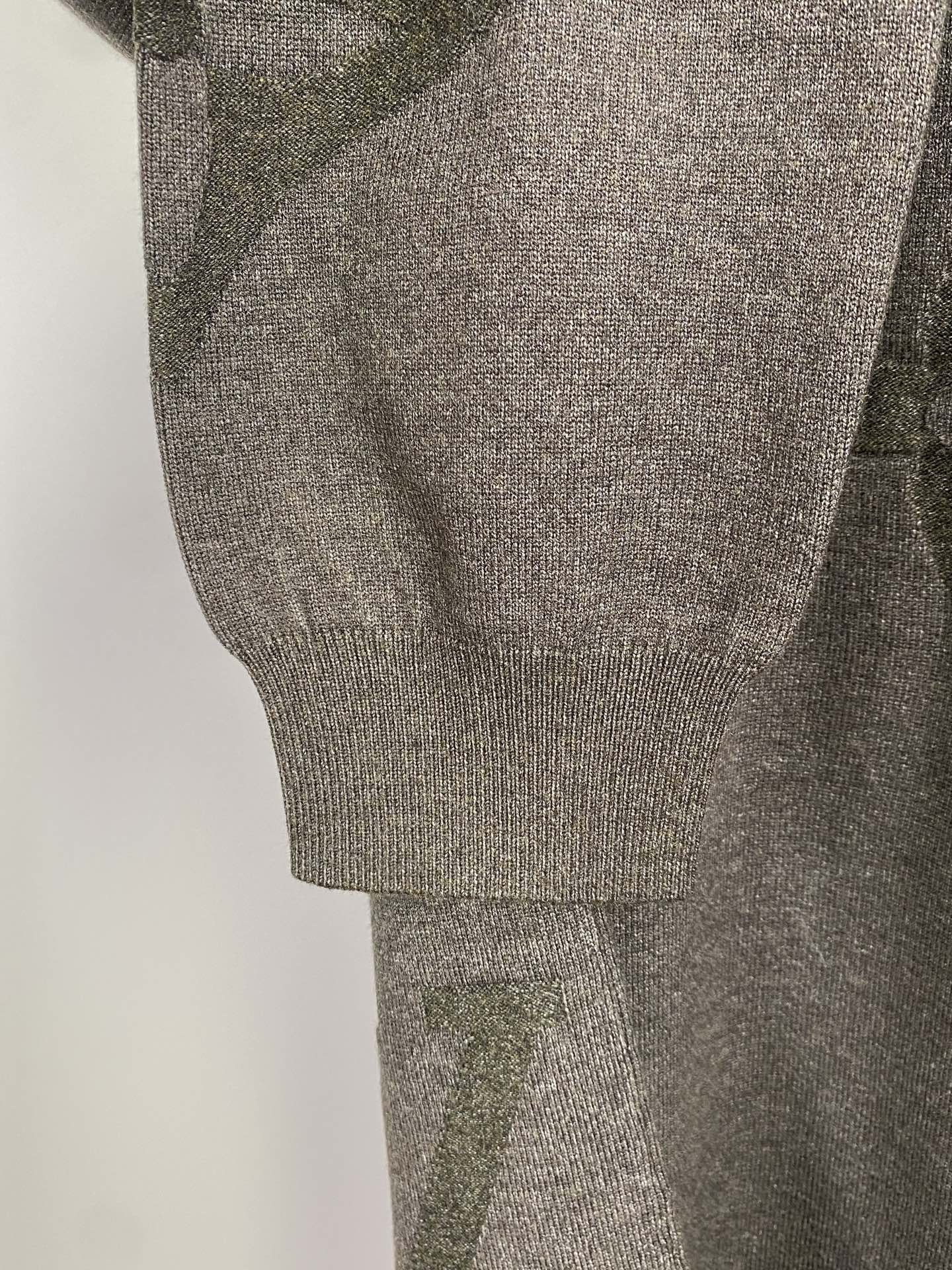 Grey knit sweater sleeve and ribbed hem cuff, logo pattern detail