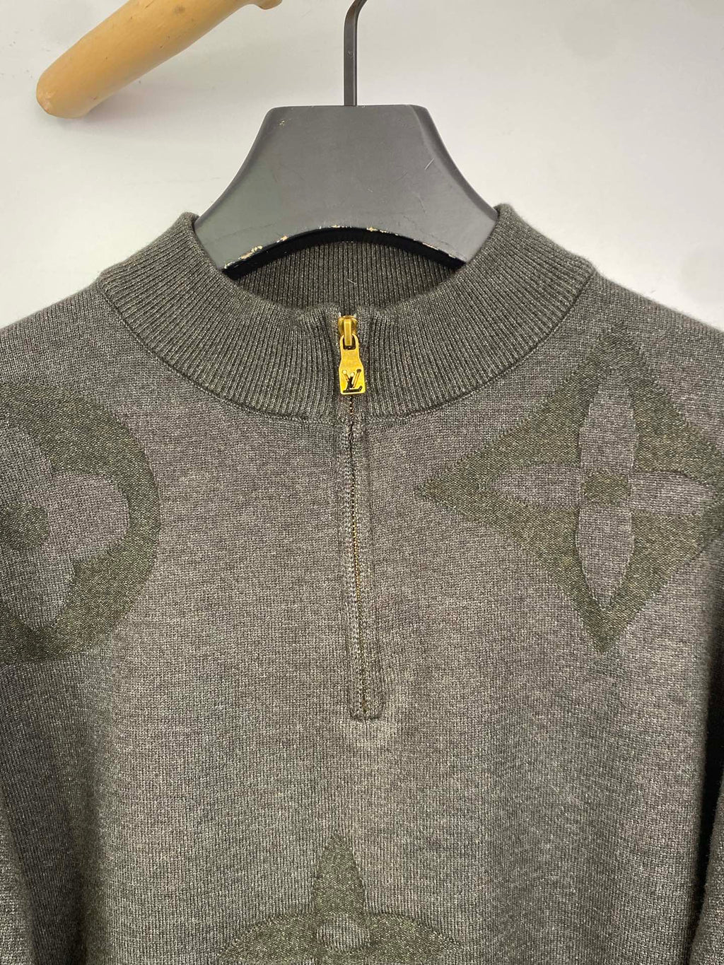 Grey knit zip sweater with yellow zipper pull and ribbed collar, close-up