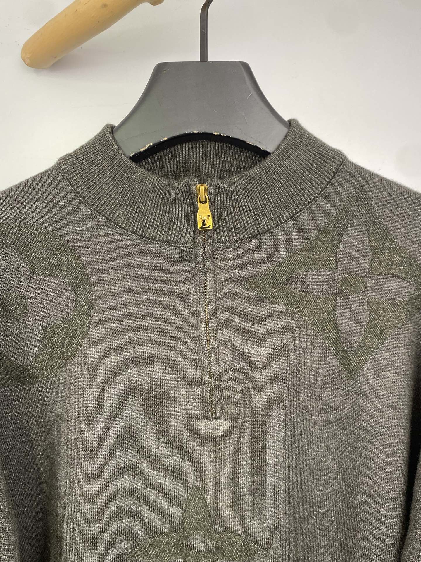 Grey knit zip sweater with yellow zipper pull and ribbed collar, close-up
