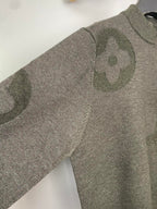 Grey knit sweater with allover logo pattern, long sleeves, angled view on hanger