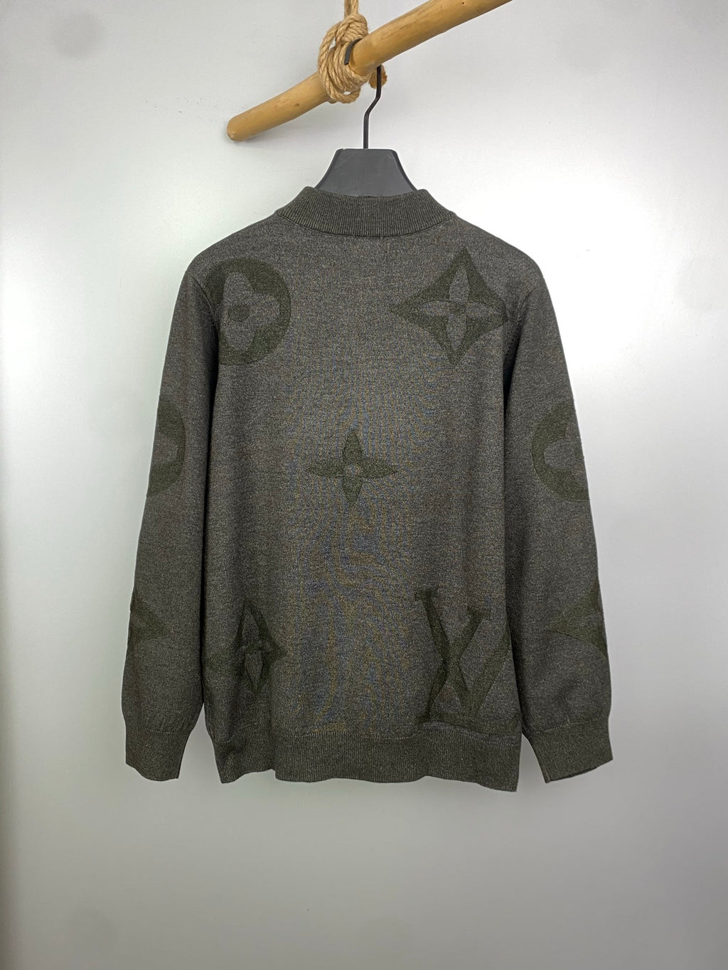 Grey knit zip sweater with logo pattern, standing collar style, on hanger