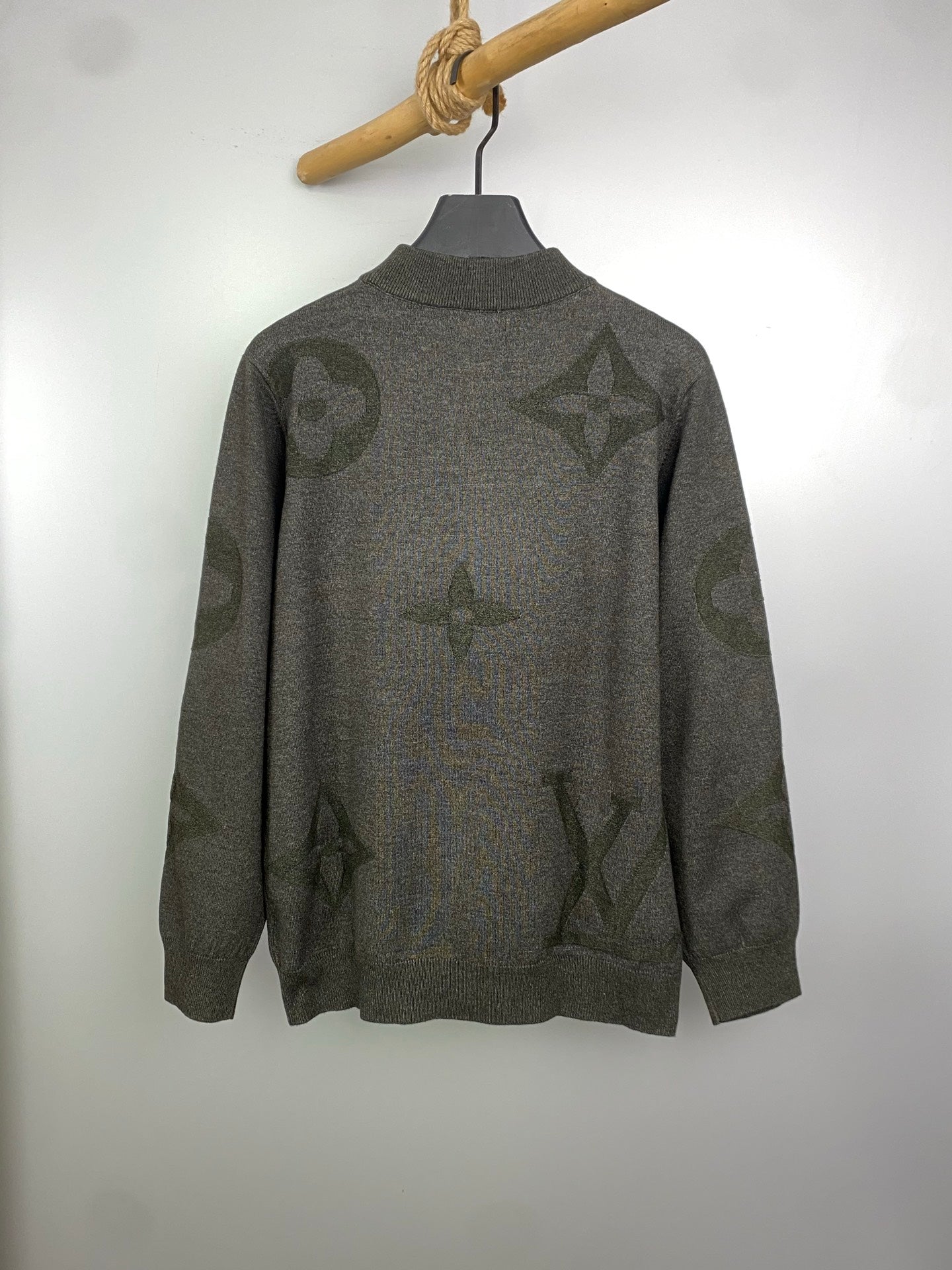 Grey knit zip sweater with logo pattern, standing collar style, on hanger