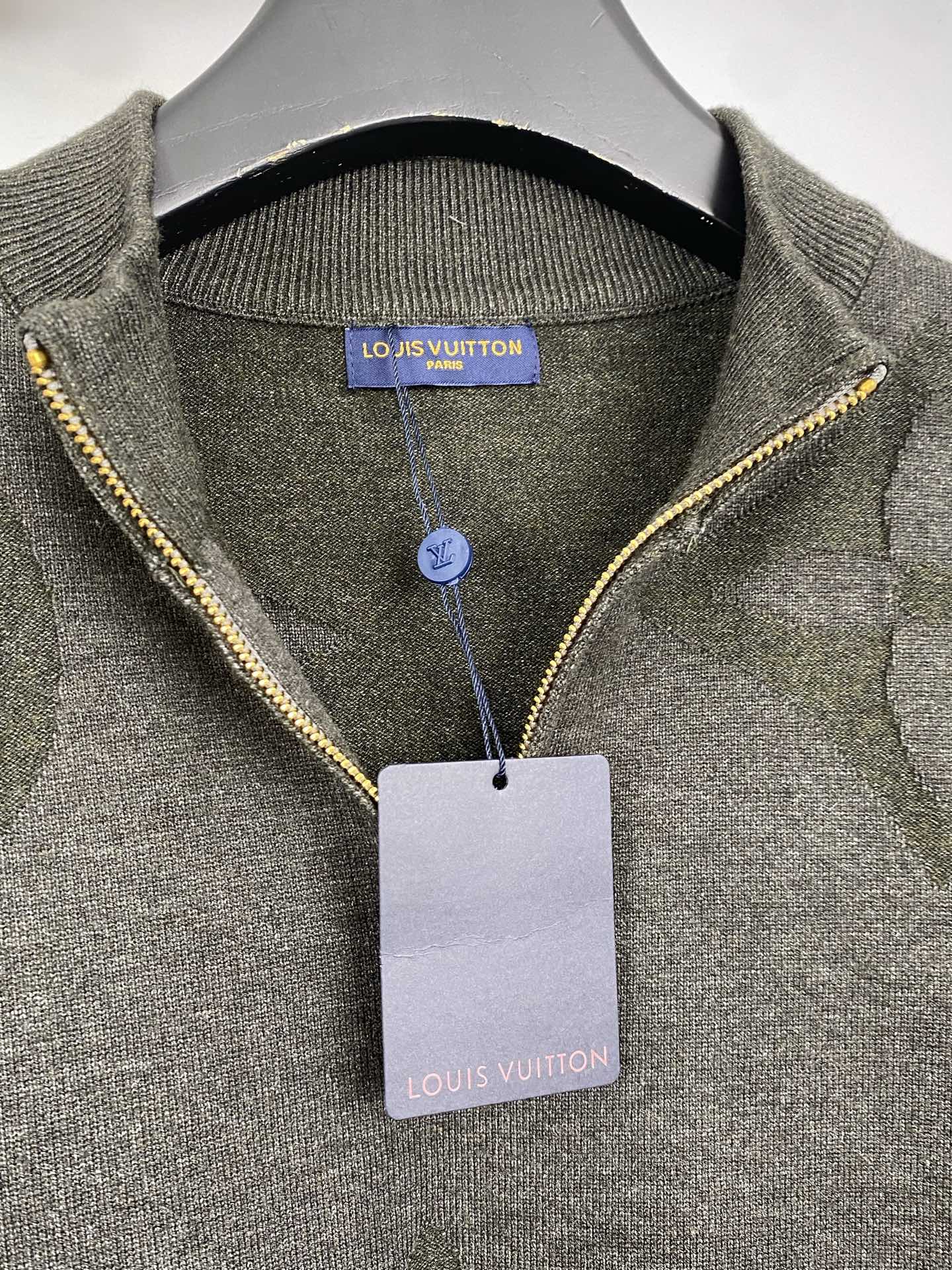 Grey knit sweater with yellow-trim zipper and interior neckline label, hanging tag