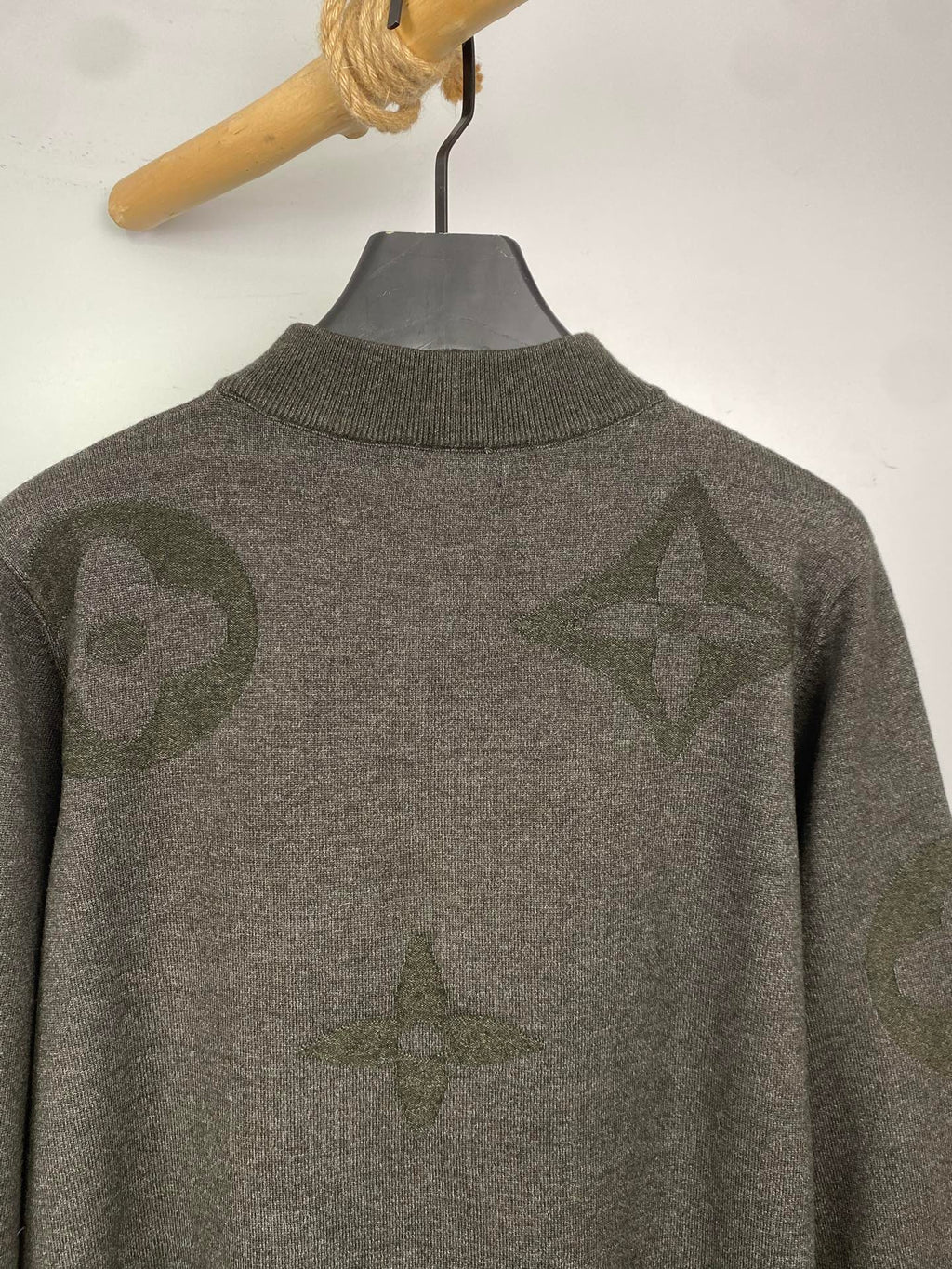 Grey knit zip sweater back view with allover logo pattern and ribbed collar