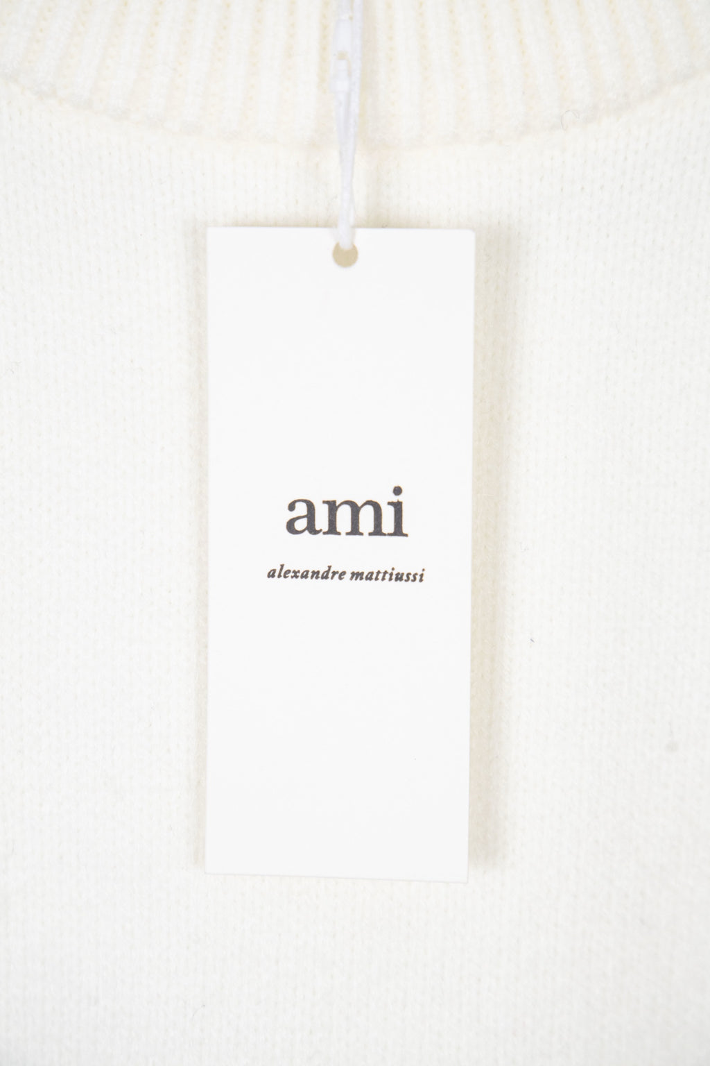 White knit sweater with ami brand hangtag