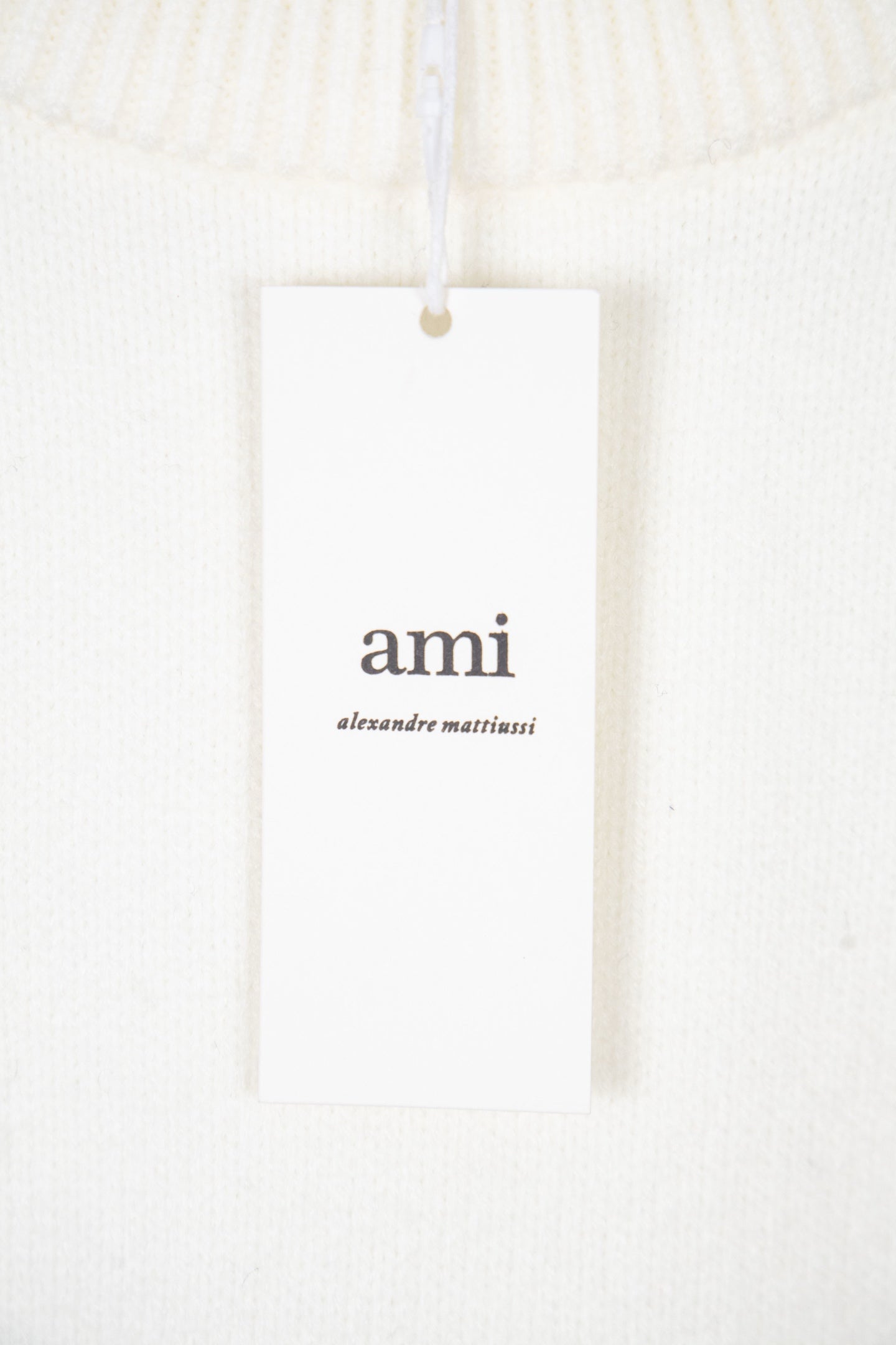 White knit sweater with ami brand hangtag