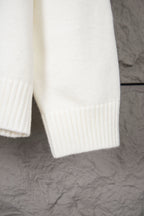 White knit sweater sleeve and lower hem with ribbed vertical knit panels