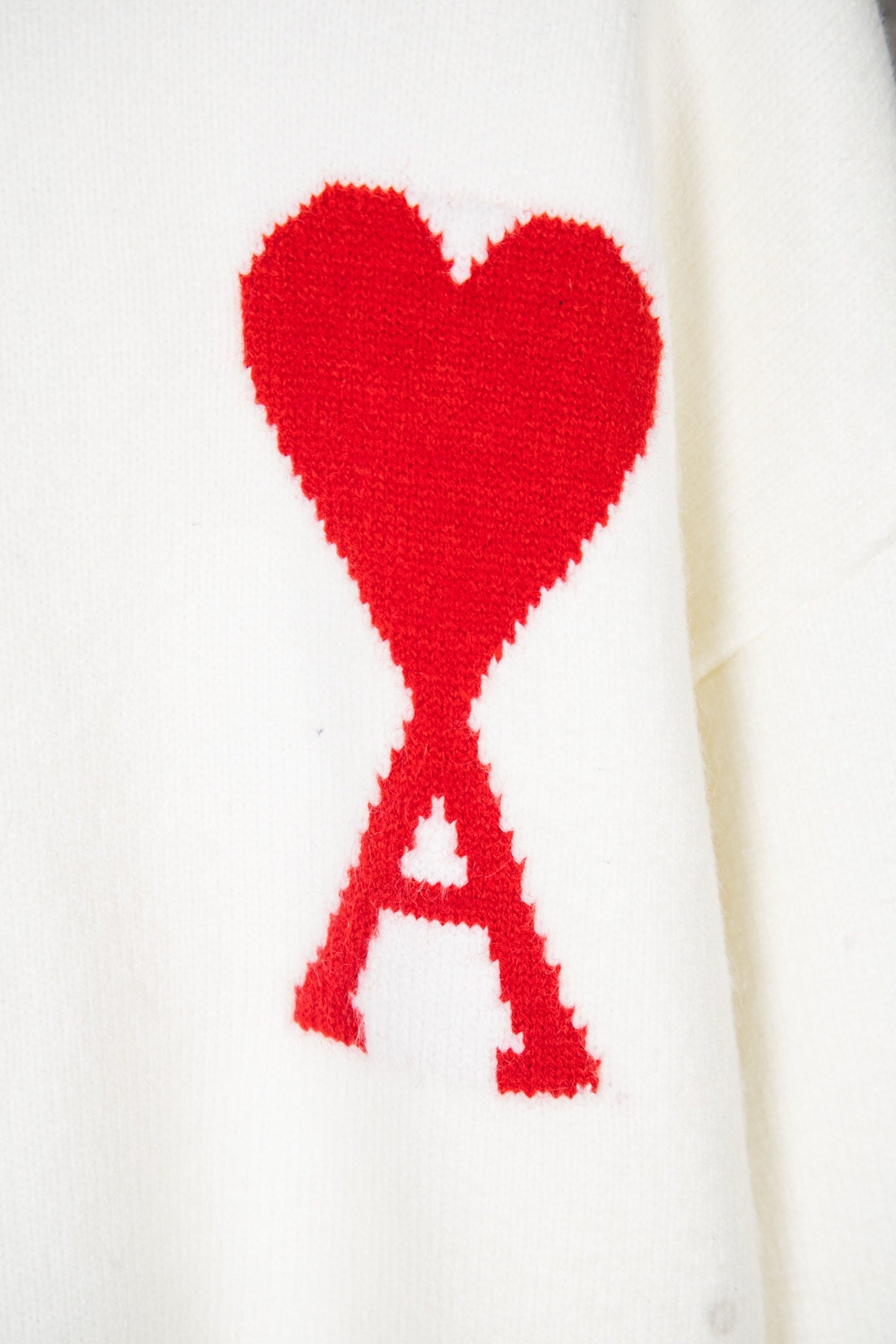 White knit sweater with red heart and red A applique graphic
