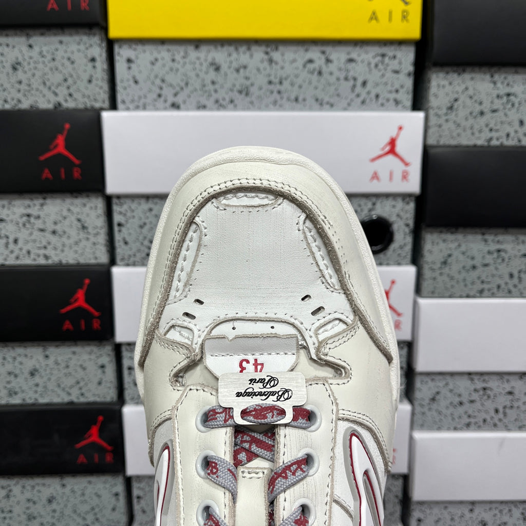 White sneaker tongue and lace area with red graphic under a gray collar