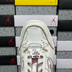 White sneaker tongue and lace area with red graphic under a gray collar