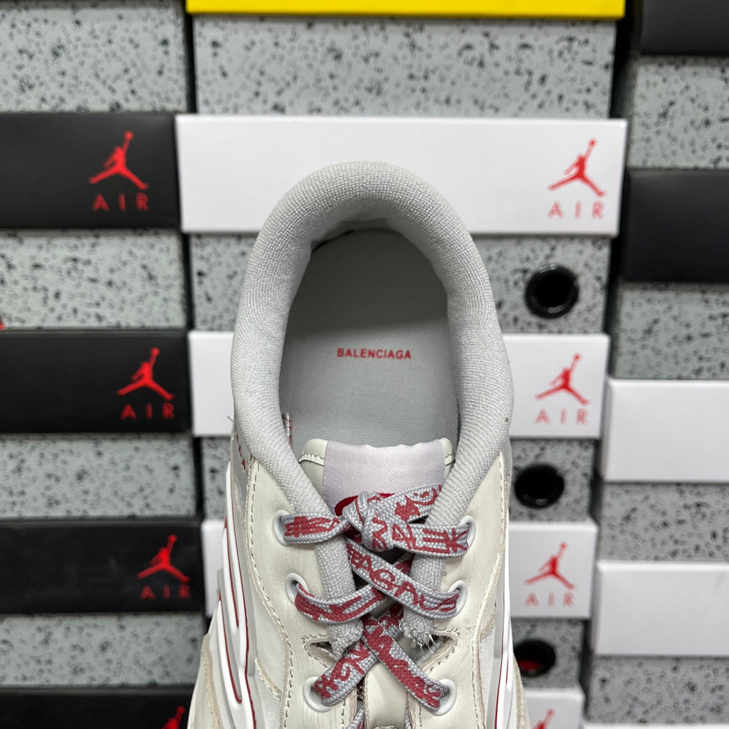 White sneaker interior view with gray collar and red lace pattern