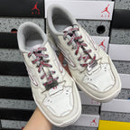White leather sneakers with red lace accents and Air branding