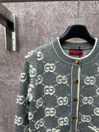 Gucci dark green cardigan detail with GG pattern, gold buttons, and ribbed hem pockets.