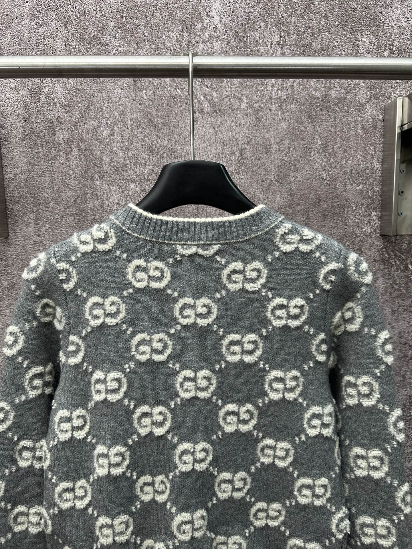 Gucci dark green knit cardigan back view with repeating GG logo pattern.