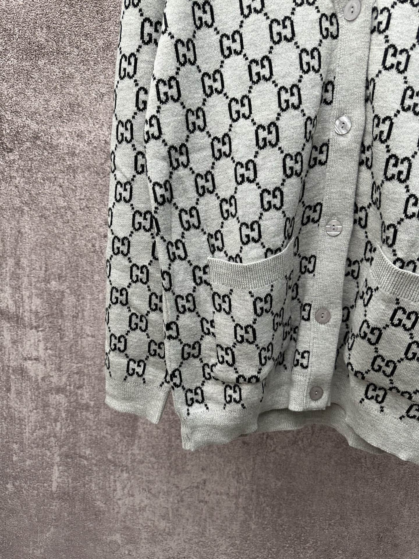 Gucci long-sleeve top with light gray body and black GG monogram repeat pattern