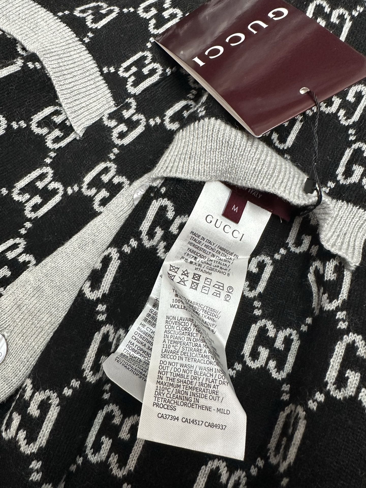 Gucci knit sweater neckline and label, black GG pattern with gray ribbing