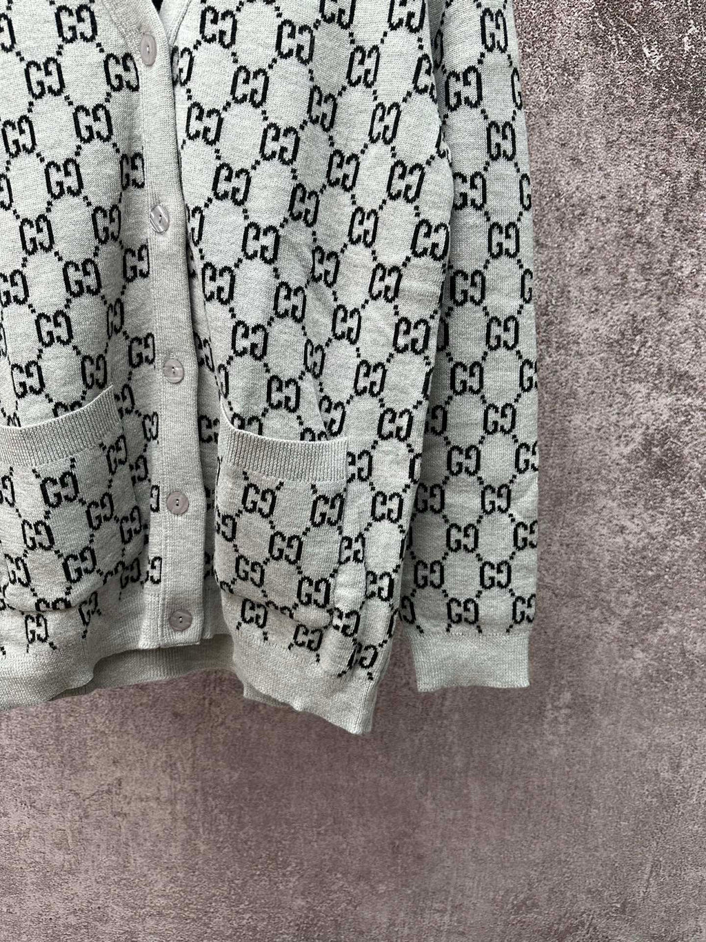 Gucci long-sleeve knit top with black GG monogram pattern and light gray sleeves