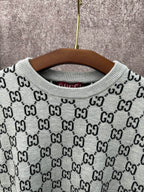Light gray knit T-shirt close-up: ribbed crew neck with black GG logo pattern