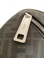 Fendi bag front zipper pull with metal logo tab and black textured fabric near zipper.