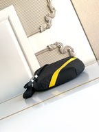 Fendi bag with dark exterior, neon yellow front stripe, and silver-toned side zipper hardware.