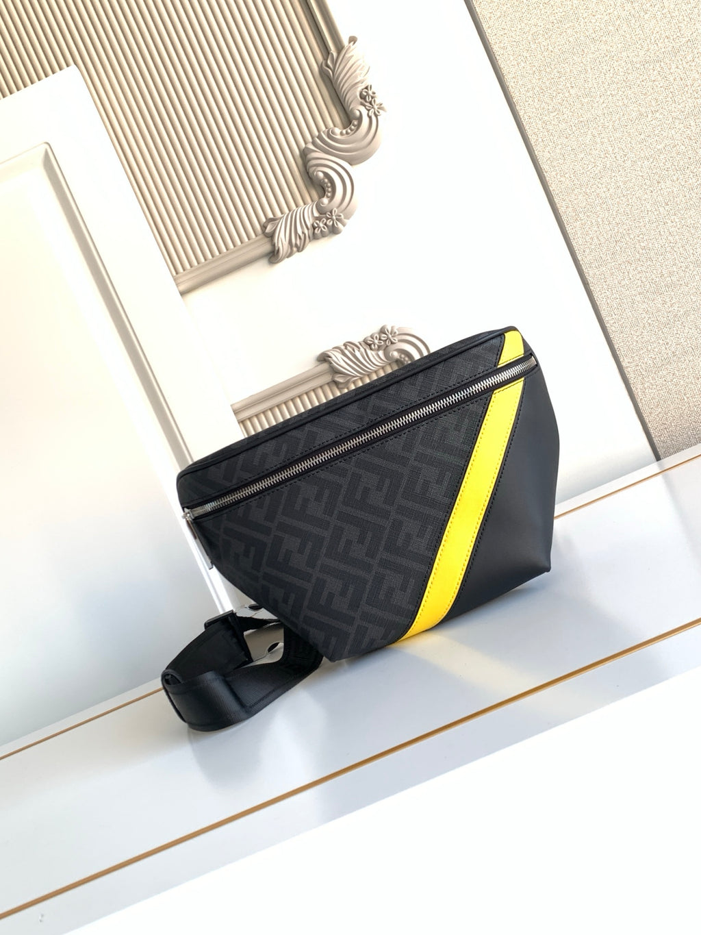 Fendi bag with dark fabric, neon yellow stripe, front zipper, and adjustable shoulder strap.