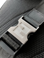 Fendi bag belt-style buckle hardware on mesh-textured panel with black stitching details.