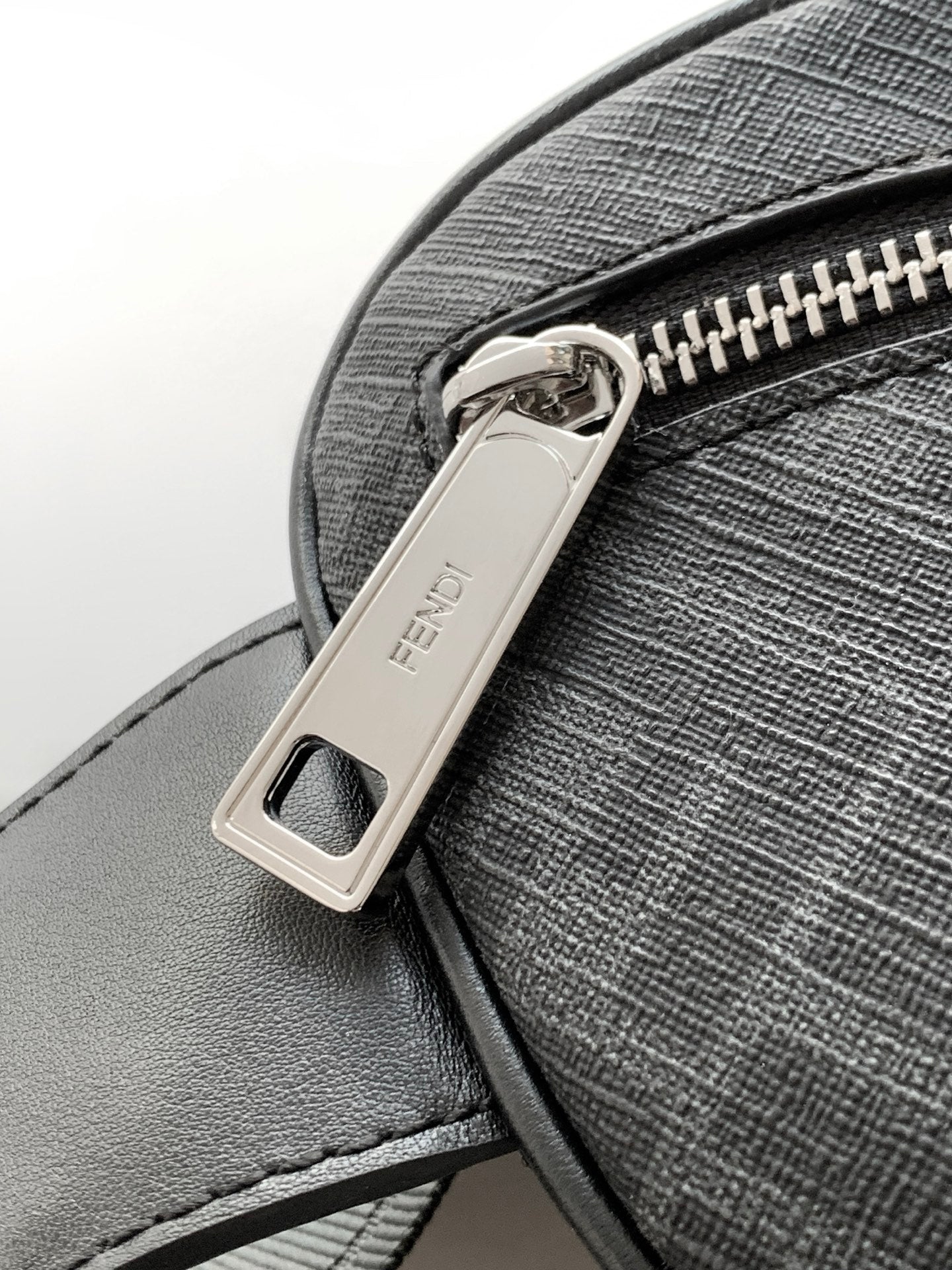 Fendi crossbody bag close-up with silver logo buckle and top zipper track