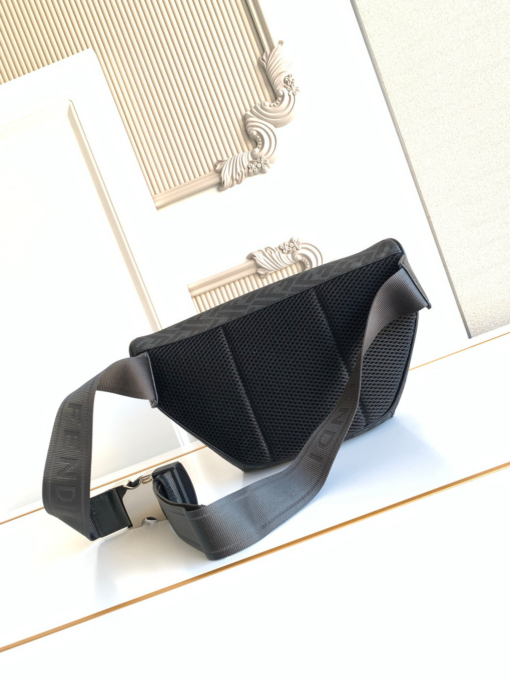 Fendi crossbody bag with dark textured flap and adjustable shoulder strap